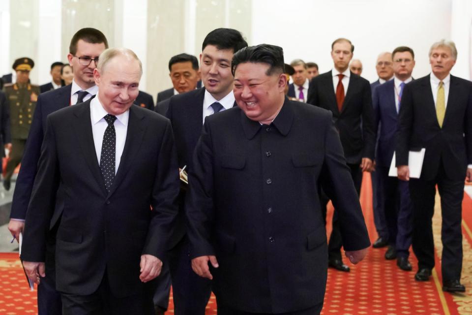 Putin and Kim Jong-un talk to each other as they walk after a signing ceremony in Pyongyang, North Korea (AP)