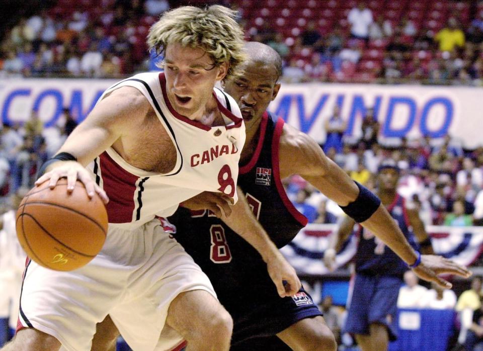 Canada's Shawn Swords, left, drives the ball past the USA's Vince Carter of the Toronto Raptors, right, during the FIBA Americas Olympic Qualifying Tournament in August 2003. 