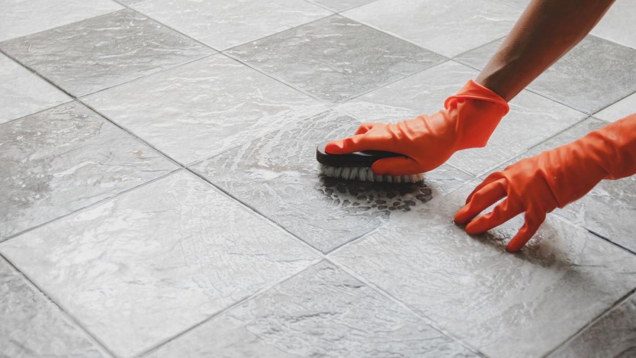 cropped hands cleaning tiled floor