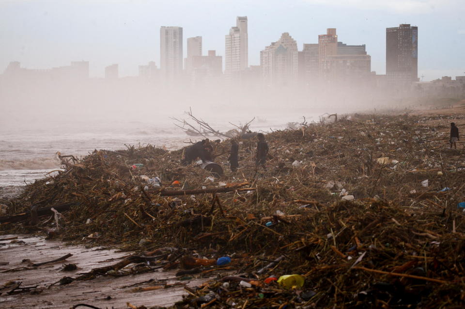 People search for items which they can salvage on the beach after heavy rains caused flooding, in Durban, South Africa, April 12, 2022. REUTERS/Rogan Ward     TPX IMAGES OF THE DAY