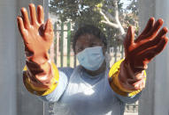 FILE - In this July 23, 2020 file photo, a health worker with rubber gloves, prepares to take nasal swabs without contact from patients to test for COVID-19 at the Masiphumelele community centre in Cape Town, South Africa, The country's success in bringing its first wave of COVID-19 under control has allowed it to almost fully reopen the economy, while monitoring for signs of a second surge, says the government's chief medical advisor. (AP Photo/Nardus Engelbrecht, file)