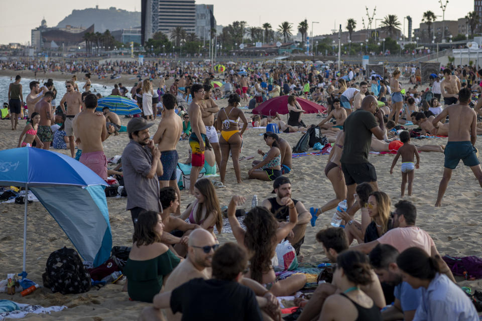 People enjoy the beach in Barcelona, Spain, Sunday, June 21, 2020. Spain ended a national state of emergency after three months of lockdown, allowing its 47 million residents to freely travel around the country for the first time since March 14. The country also dropped a 14-day quarantine for visitors from Britain and the 26 European countries that allow visa-free travel. (AP Photo/Emilio Morenatti)