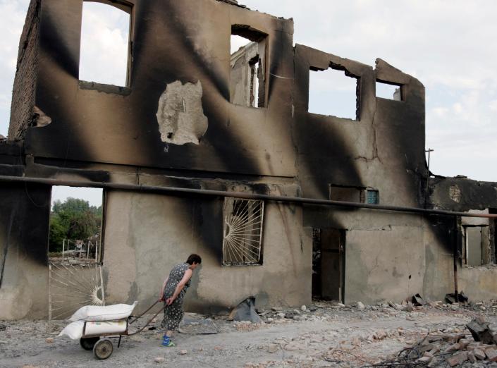 A woman walks past a destroyed building in Tskhinvali, in the Georgian breakaway province of South Ossetia, on Aug. 16, 2008.