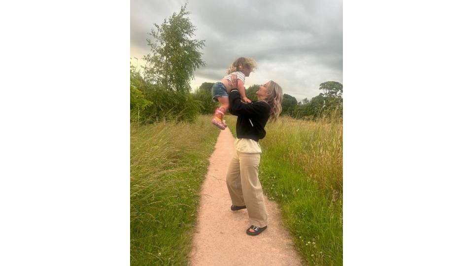 mother holding daughter in air