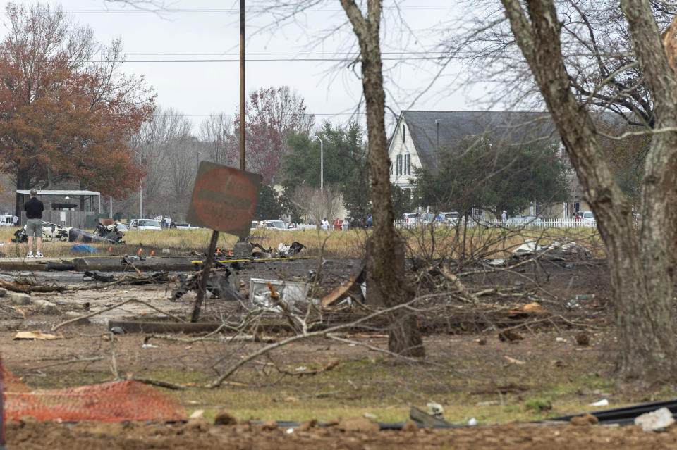 A view of the burnt wreckage of a small plane that crashed into the parking lot of a post office is shown, at left, in Lafayette, La., Saturday, Dec. 28, 2019. Several people died in the crash. (Scott Clause/The Lafayette Advertiser via AP)