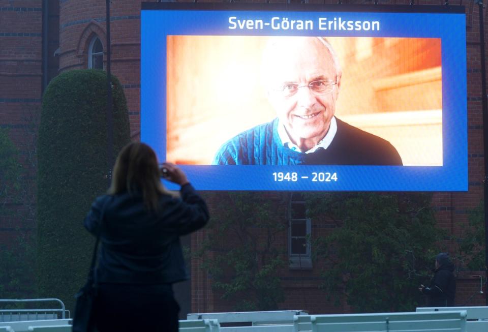 A person takes a picture of the screen outside Fryksande Church in Torsby (Yui Mok/PA Wire)