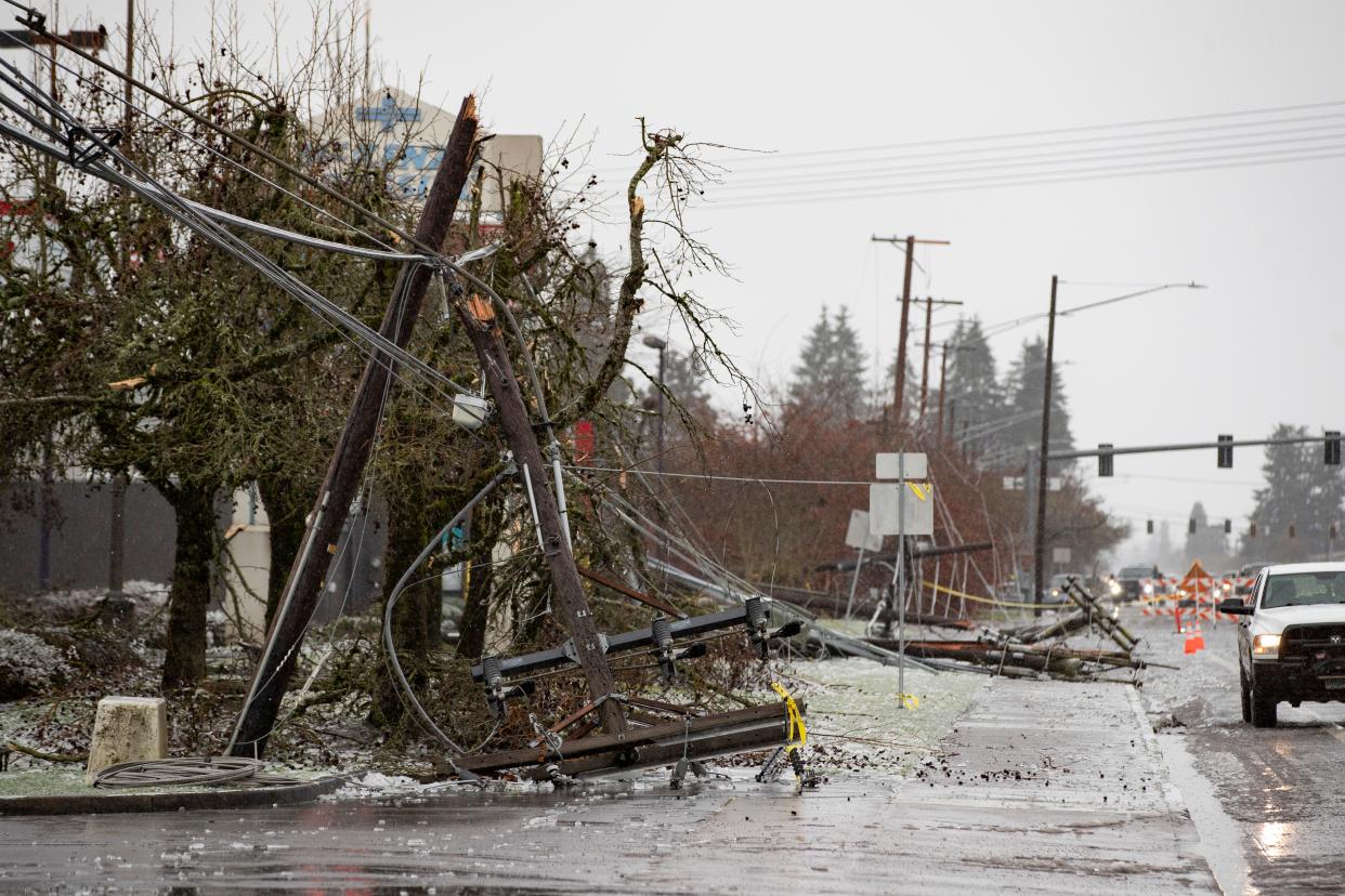 Utility lines rest on the sidewalk along Main Street near Bob Straub Parkway in Springfield on Wednesday following a series of winter storms including an ice storm overnight.