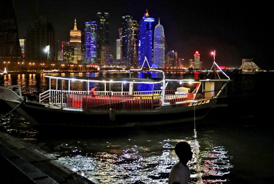 A man walks along the waterfront, in Doha, Qatar.