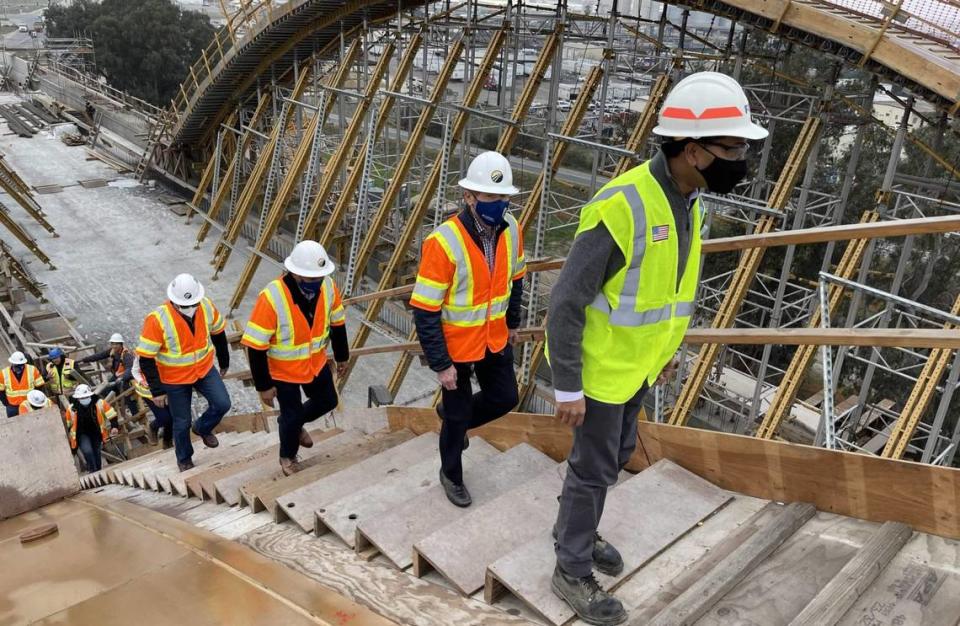 Federal Railroad Administration deputy administrator Amit Bose, far right, and officials from the California High-Speed Rail Authority climb stairs to the top of the Cedar Avenue high-speed rail viaduct above Highway 99 at the south end of Fresno, CA, during a construction site tour on Dec. 7, 2021.