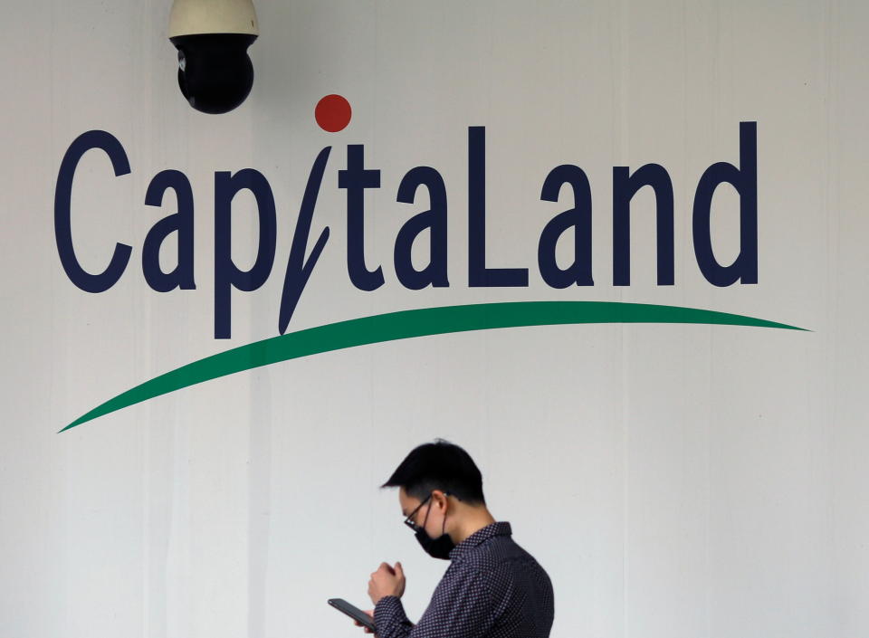 A man passes a CapitaLand signage in Singapore March 22, 2021. REUTERS/Edgar Su