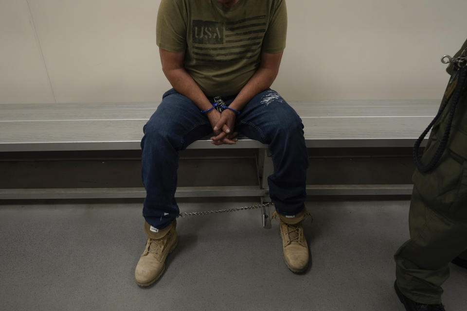 FILE - An immigrant considered a threat to public safety and national security waits to be processed by U.S. Immigration and Customs Enforcement agents at the ICE Metropolitan Detention Center in Los Angeles, after an early morning raid, June 6, 2022. The Biden administration is asking the Supreme Court to allow it to put in place guidance that prioritizes deportation of people in the country illegally who pose the greatest public safety risk. (AP Photo/Damian Dovarganes, File)