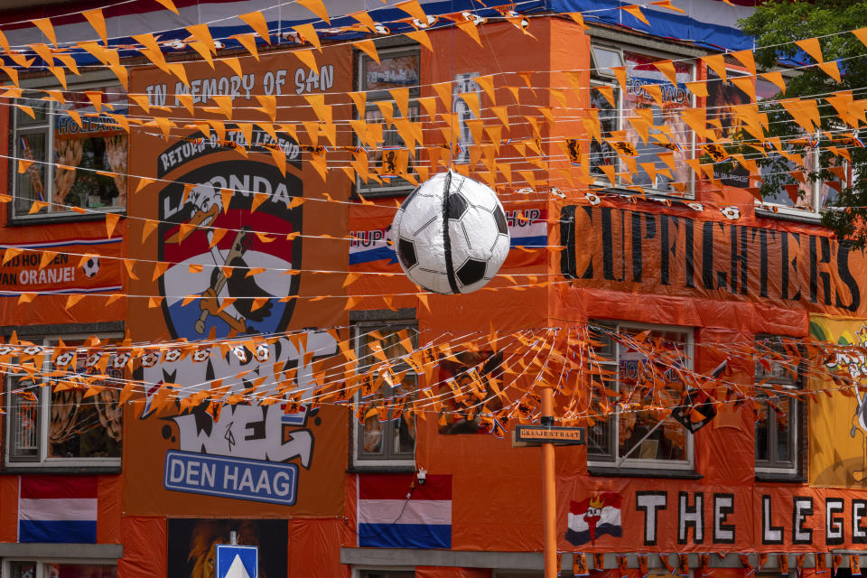 Inflatable soccer balls, orange tarp, orange bunting, and Dutch national flags decorate Marktweg street in The Hague, Netherlands, Thursday June 13, 2024, one day ahead of the start of the Euro 2024 Soccer Championship. (AP Photo/Peter Dejong)