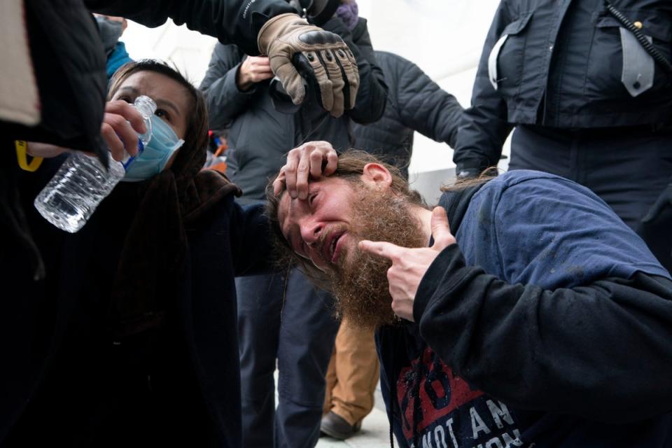 Supporters of President Donald Trump puts water in his eyes after U.S. Capitol Police deployed a chemical agent outside of the U.S. Capitol (AP)