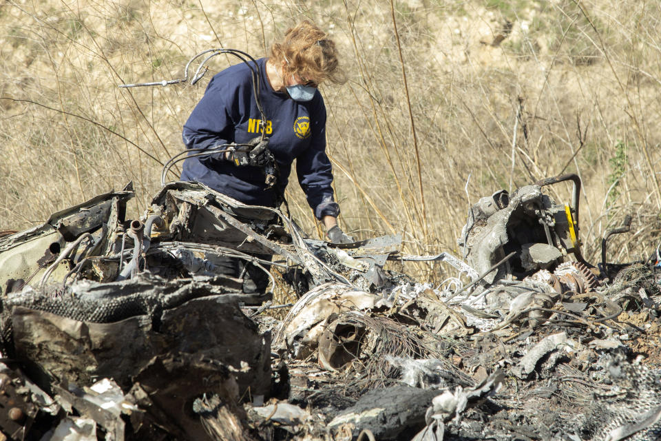 FILE - In this Jan. 27, 2020, file photo released by the National Transportation Safety Board, NTSB investigator Carol Hogan examines wreckage as part of the NTSB's investigation of a helicopter crash near Calabasas, Calif., that killed former NBA basketball player Kobe Bryant, his 13-year-old daughter, Gianna, and seven others. Bryant's widow Vanessa Bryant on Tuesday, Sept. 22, 2020, filed a lawsuit against the Los Angeles County sheriff alleging negligence, invasion of privacy and intentional infliction of emotional distress after deputies allegedly shared unauthorized photos of the crash that killed her husband, their 13-year-old daughter and seven others. (James Anderson/National Transportation Safety Board via AP, File)