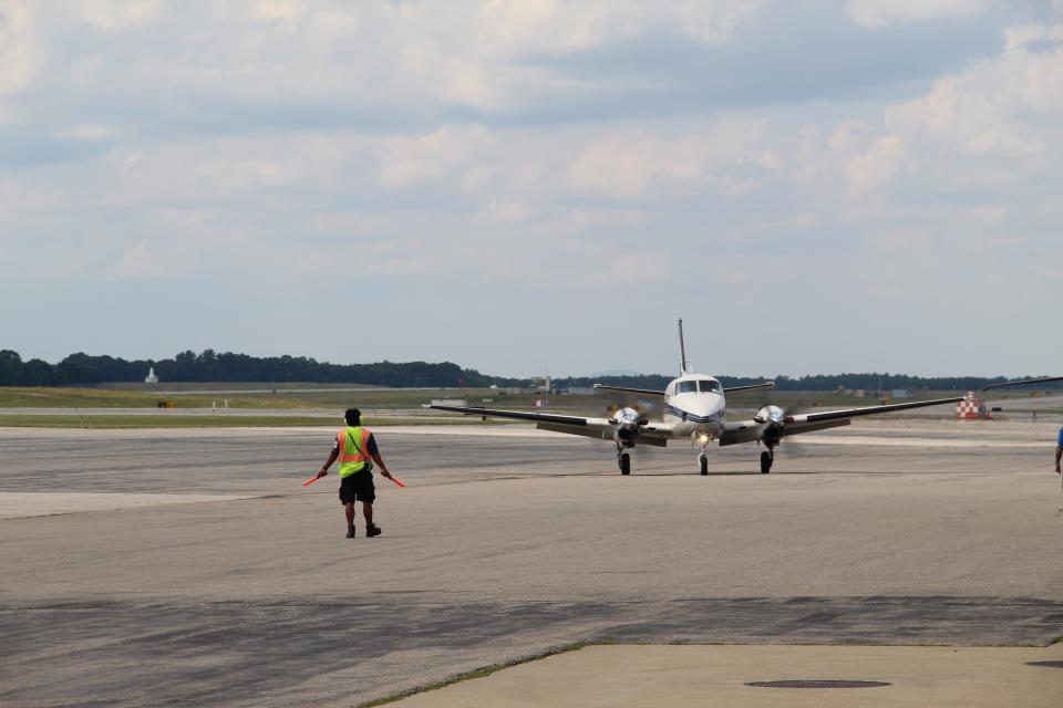 Daniel Cerritos guides a plane that just landed into the Port City Air holding area Tuesday, Aug. 2, 2022 at Portsmouth International Airport at Pease.