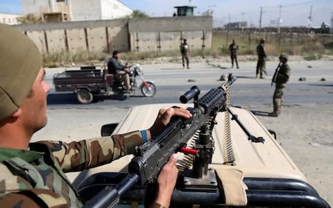 Afghan National Army soldiers stand guard at a checkpoint ahead of parliamentary elections, in Kabul, Afghanistan - Credit: AP