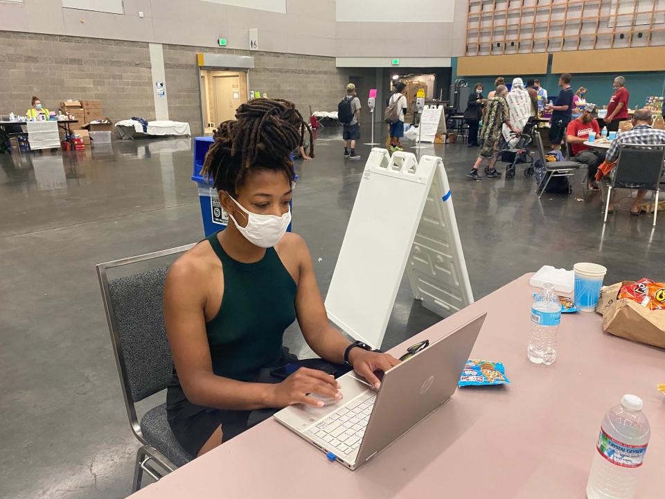 M.J. Jackson works at her laptop at the Oregon Convention Center, which doubled as a 24-hour cooling station over the weekend as Portland experienced a record-setting heat wave that exceeded 112 degrees.