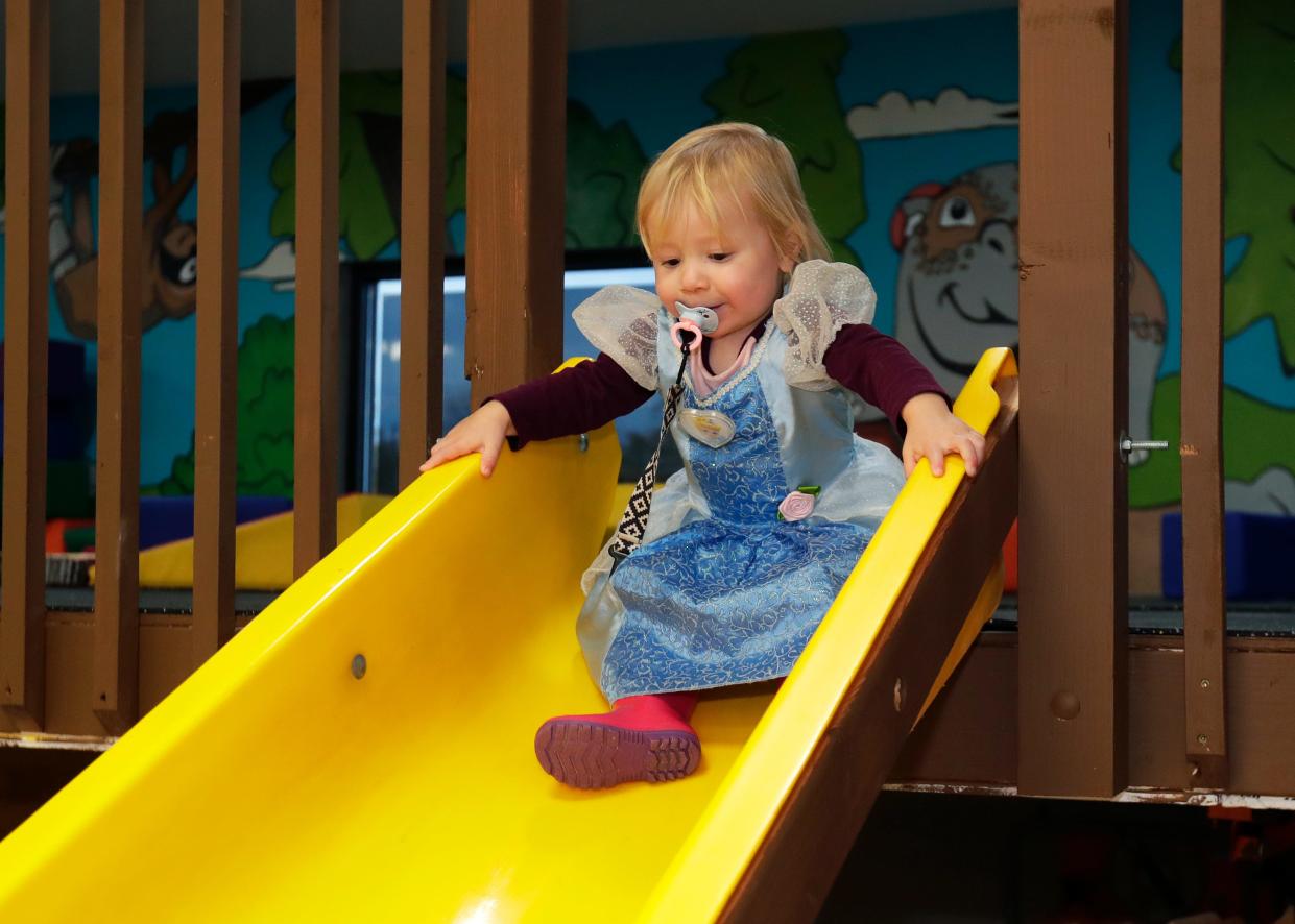Bethany Fayas, 2, of De Pere, goes down the slide in the new learning and play area of You Belong in Ashwaubenon.