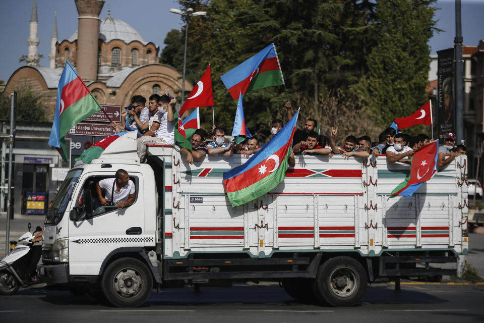 Demonstrators, holding Turkish and Azerbaijani flags, are carried on a truck during a protest supporting Azerbaijan, in Istanbul, Sunday, Oct. 4, 2020. Armenian and Azerbaijani forces continue their fighting over the separatist region of Nagorno-Karabakh, following the reigniting of a decades-old conflict. Turkey, which strongly backs Azerbaijan, has condemned an attack on Azerbaijan's second largest city Gence and said the attack was proof of Armenia's disregard for law. (AP Photo/Emrah Gurel)