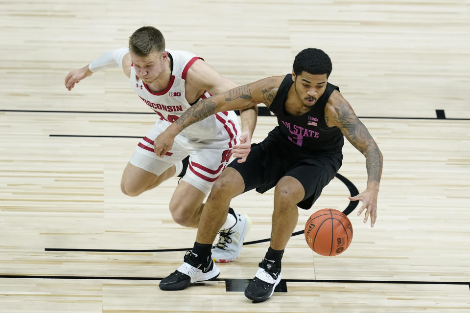 Penn State's Sam Sessoms (3) chases down a loose ball against Wisconsin's Brad Davison (34) during the first half of an NCAA college basketball game at the Big Ten Conference tournament, Thursday, March 11, 2021, in Indianapolis. (AP Photo/Darron Cummings)