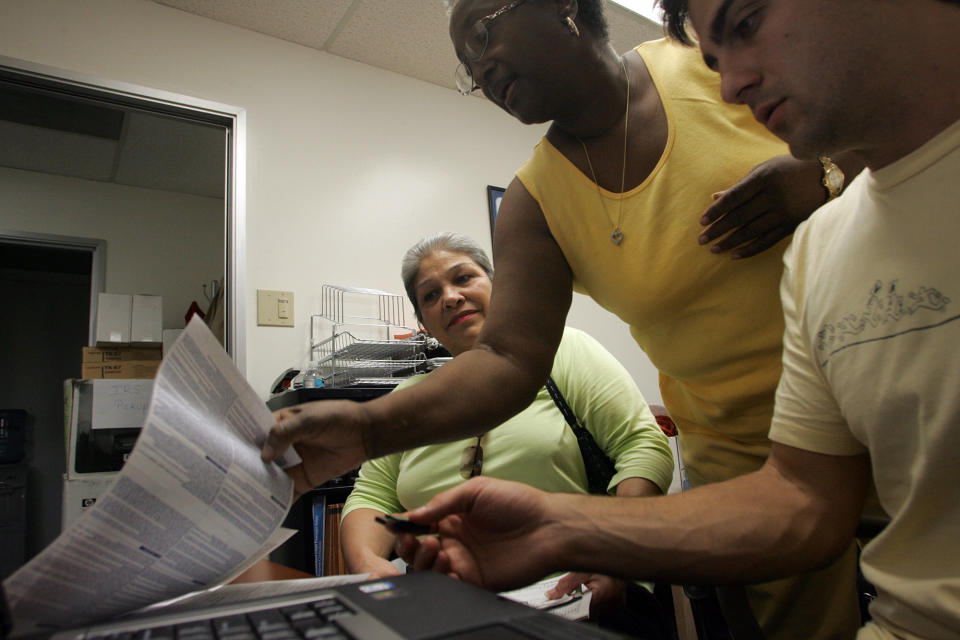 Dora Galvan (left/sitting) has her taxes prepared at the Inglewood location of the Southern California Tax Assistance Program with the assistance of Elnora Rayland, (middle) who works for Broad Spectrum, and Brian Harlan (right), a 2nd year law student who is a VITA volunteer.  (Photo by Gary Friedman/Los Angeles Times via Getty Images)