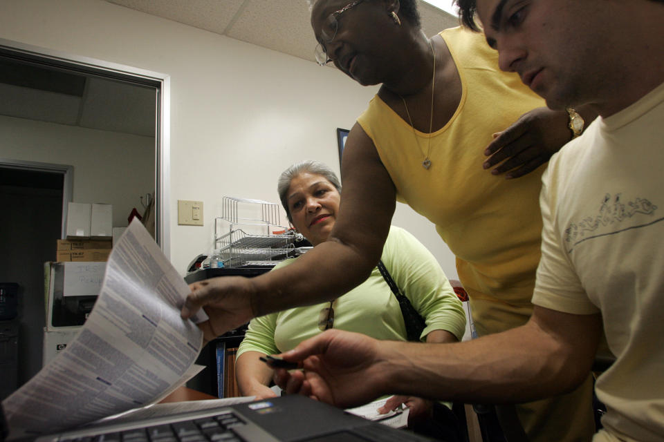 Dora Galvan (left/sitting) has her taxes prepared at the Inglewood location of the Southern California Tax Assistance Program with the assistance of Elnora Rayland, (middle) who works for Broad Spectrum, and Brian Harlan (right), a 2nd year law student who is a VITA volunteer. (Photo by Gary Friedman/Los Angeles Times via Getty Images)