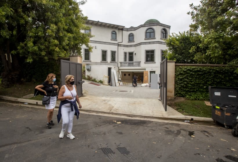 HOLMBY HILLS, CA - AUGUST 06: Passersby watch as party rental crews pack up at the scene of a wedding at 10350 Wyton Drive on Thursday, Aug. 6, 2020 in Holmby Hills, CA. Police reacting to noise complaints shut down the wedding reception after receiving multiple noise complaints Wednesday night.(Brian van der Brug / Los Angeles Times)