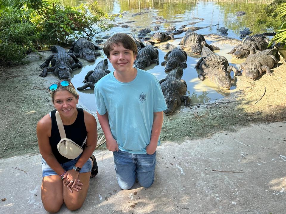 Terri Peters and her son posing with a group of alligators at Gatorland