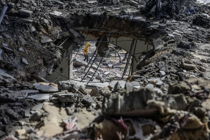 Palestinians inspect rubble of a destroyed house belongs to the Tawabta family after an Israeli air strike, which resulted in a large number of deaths and injuries. Abed Rahim Khatib/dpa