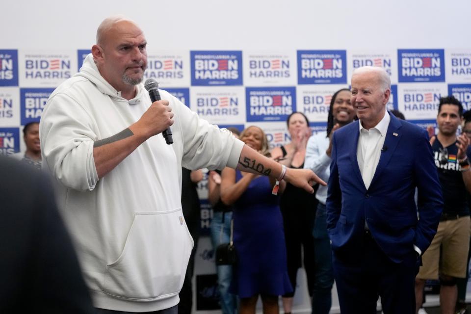 Biden listens as senator John Fetterman speaks in Philadelphia (AP)