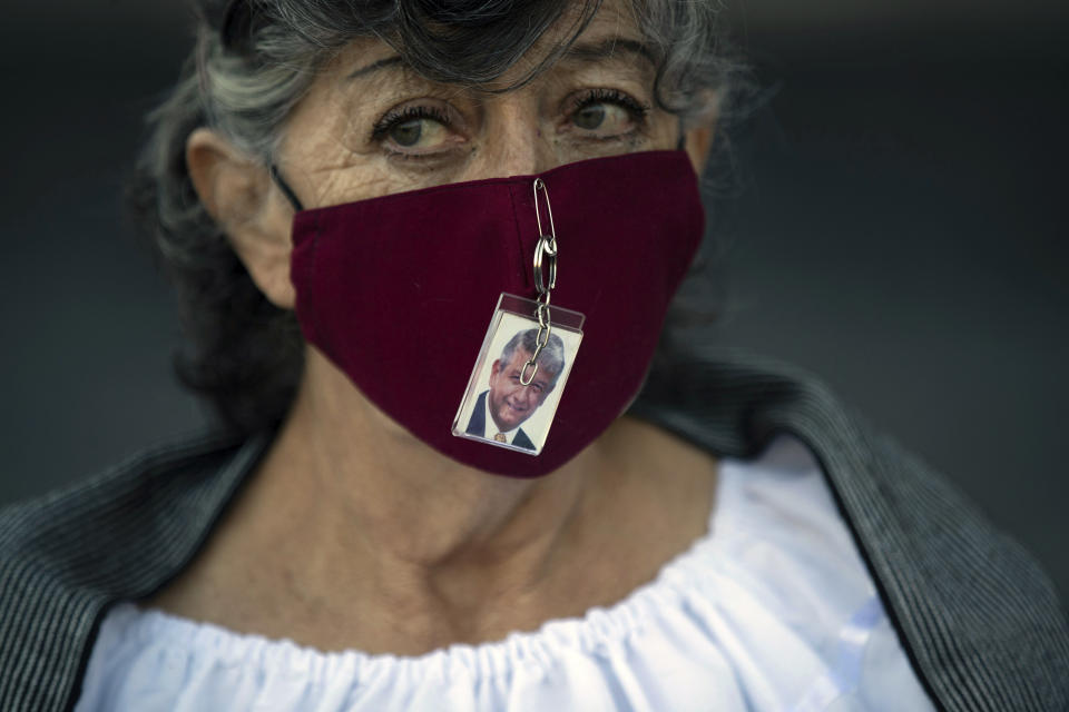 A supporter of Mexican President Andres Manuel Lopez Obrador wears a mask with a photo of him pinned to it outside the presidential palace as the president delivers his second state-of-the-union address inside, in Mexico City, Tuesday, Sept. 1, 2020. Obrador emphasized what he considers his major achievements: the fight against corruption and his government’s austerity. (AP Photo/Fernando Llano)