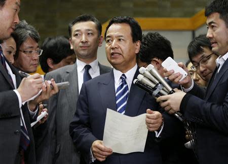 Japan's Economics Minister Akira Amari (C) speaks as he is surrounded by media after meetings with U.S. Trade Representative Michael Froman (not in picture) in Tokyo April 10, 2014. REUTERS/Issei Kato