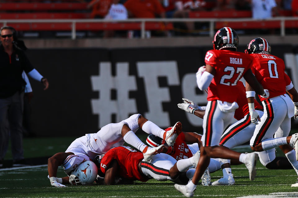 LUBBOCK, TEXAS - SEPTEMBER 26: Running back Bijan Robinson #5 of the Texas Longhorns is hit by linebacker Riko Jeffers #6 of the Texas Tech Red Raiders during the second half of the college football game on September 26, 2020 at Jones AT&T Stadium in Lubbock, Texas. (Photo by John E. Moore III/Getty Images)