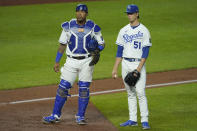 Kansas City Royals starting pitcher Brady Singer and catcher Salvador Perez wait while a play is reviewed during the sixth inning of a baseball game against the Cleveland Indians Wednesday, May 5, 2021, in Kansas City, Mo. (AP Photo/Charlie Riedel)