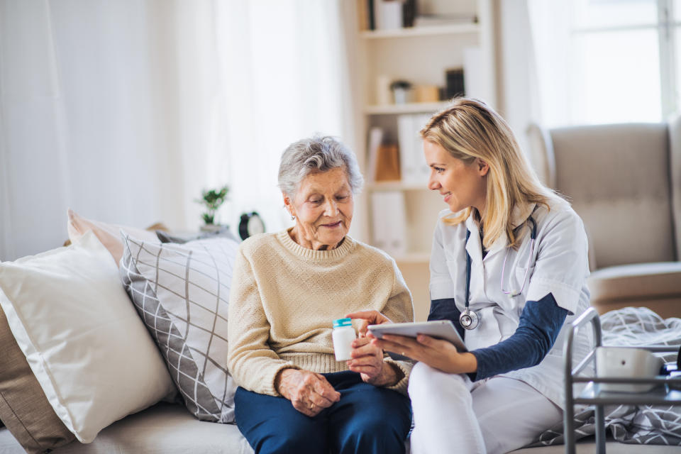 Nurse speaking with mature woman in her house about a medication