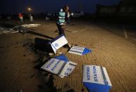 Election officials examine the remains of ballot boxes after a voting tent was burnt down overnight in Bekkersdal, near Johannesburg May 7, 2014. (REUTERS/Mike Hutchings)
