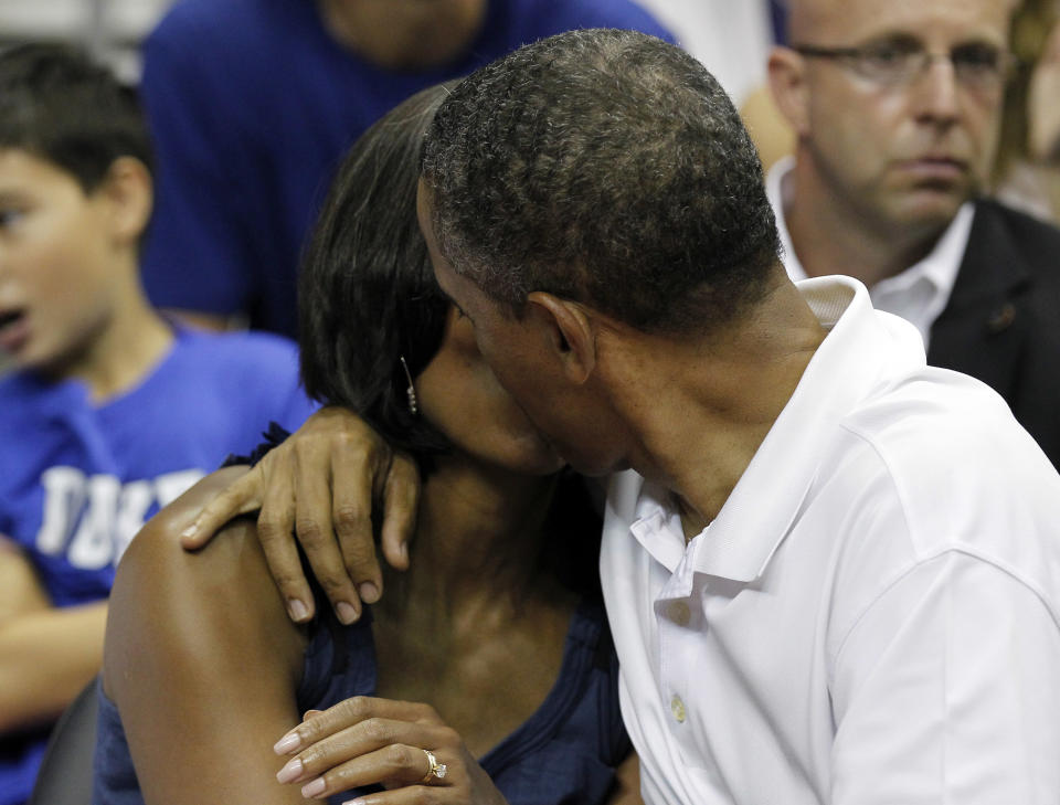 President Barack Obama kisses first lady Michelle Obama for the 'Kiss Cam' while attending the Olympic men's exhibition basketball game between Team USA and Brazil, Monday, July 16, 2012, in Washington.