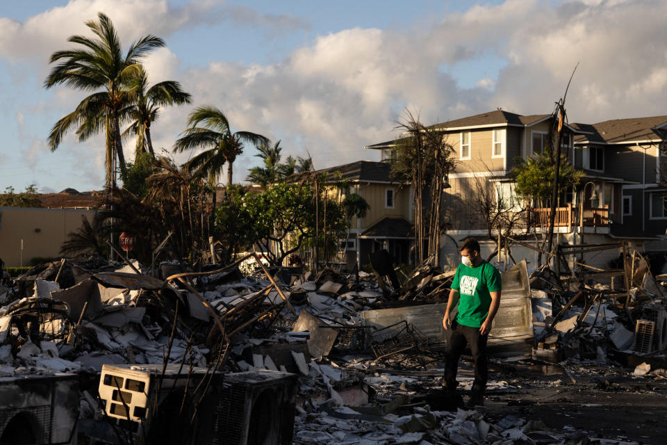 A Mercy Worldwide volunteer assesses the damage to a charred apartment complex in the aftermath of a wildfire in Lahaina, western Maui, Hawaii on Aug. 12, 2023. / Credit: YUKI IWAMURA/AFP via Getty Images