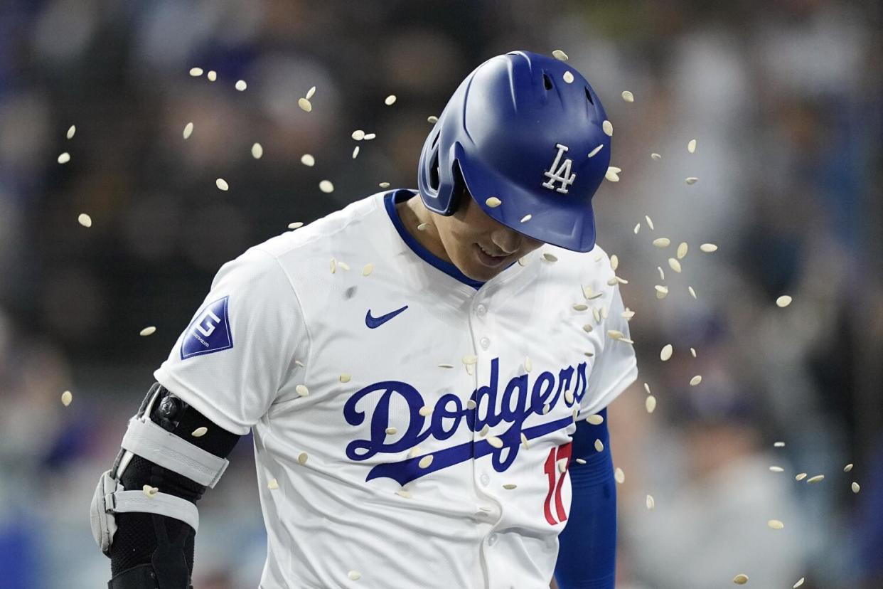 Shohei Ohtani is hit with pumpkin seeds by a teammate after hitting a solo home run.