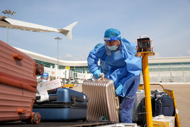 Workers transports luggage on airport tarmac in Wuhan