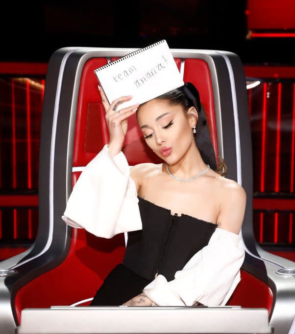 Ariana holding a "team ariana" sign on The Voice