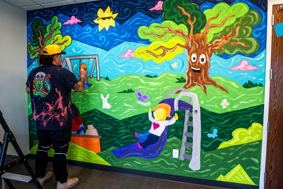 Siriaco "Siricasso" Garcia paints a mural at Midwest Autism Center in West Des Moines.