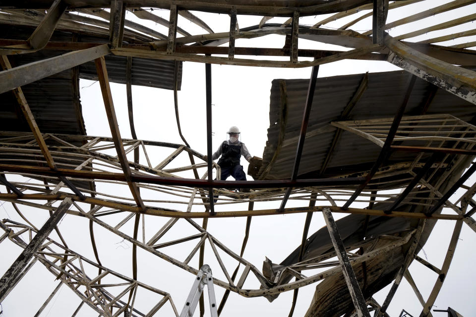 A man works on what is left of the Cristo Esperanza Viva church damaged by a forest fire, in Vina del Mar, Chile, Tuesday, Feb. 6, 2024. (AP Photo/Esteban Felix)