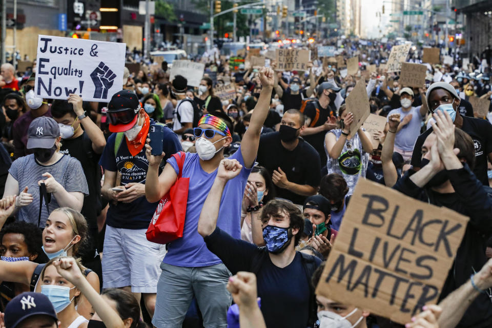 Protesters raise their fists and cheer as they march up Sixth Avenue on their way towards Columbus Cirle, Wednesday, June 3, 2020, in the Manhattan borough of New York. Protests continued following the death of George Floyd, who died after being restrained by Minneapolis police officers on Memorial Day. (AP Photo/John Minchillo)