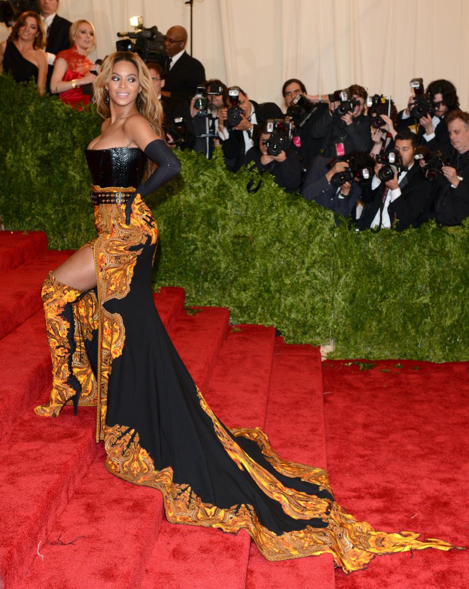 beyonce wearing black and gold gown with train and gold boots at the 2013 met gala