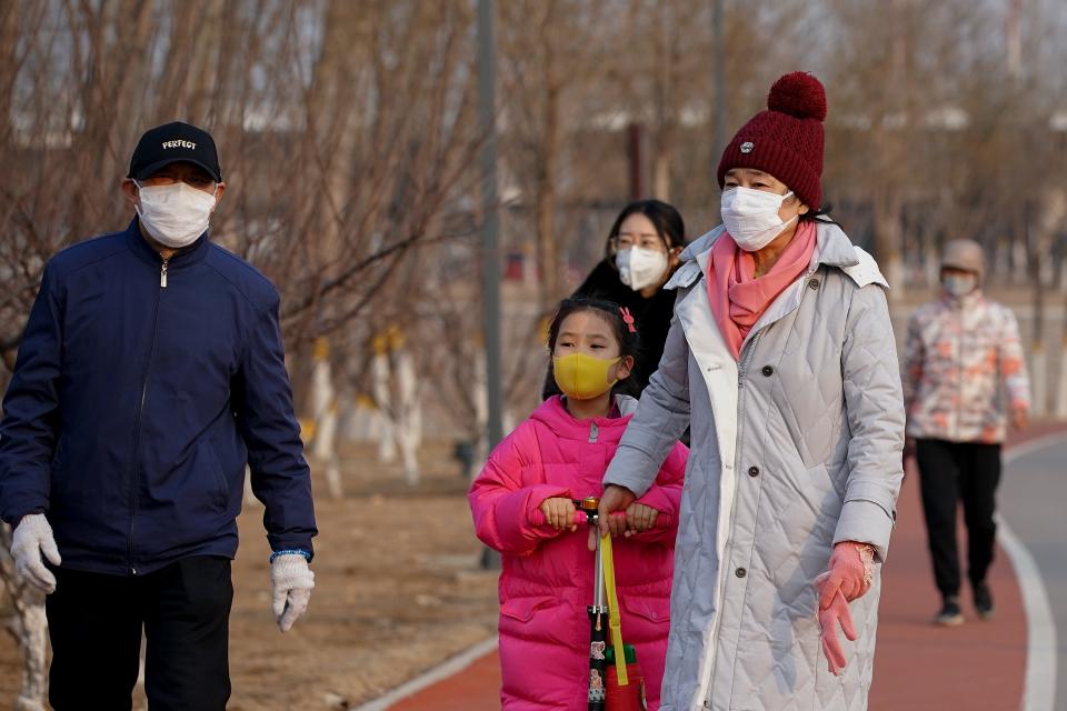 People wear face masks during a visit to a park in Beijing on Feb. 29, 2020.