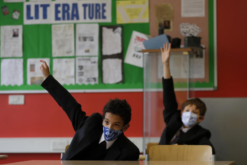 FILE - In this Thursday, Sept. 3, 2020 file photo year seven pupils Henry Holness, left, and Eddie Favell in class during their first day at Kingsdale Foundation School in London. Schools in England are starting to reopen with special measures in place to deal with Coronavirus. (AP Photo/Kirsty Wigglesworth, File)