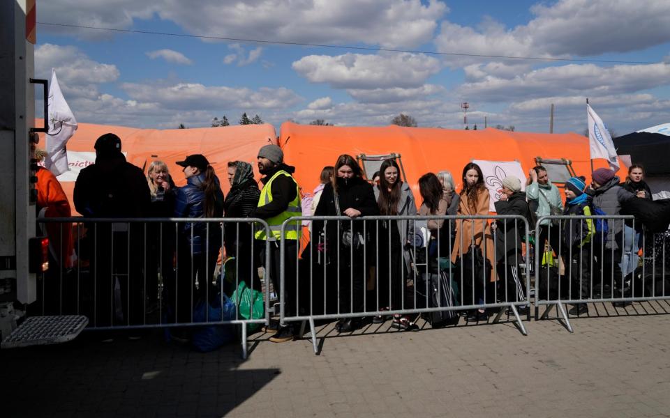 Refugees wait in a line after fleeing the war from neighbouring Ukraine at the border crossing in Medyka, southeastern Poland, Tuesday, April 12, 2022. - AP Photo/Sergei Grits