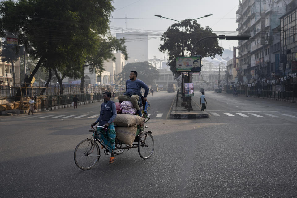 A man sits on top of goods loaded on a rickshaw crossing a deserted street ahead of general elections in Dhaka, Bangladesh, Saturday, Jan. 6, 2024. Bangladesh’s main opposition party has enforced a 48-hour general strike from Saturday across the South Asian nation as the nation is ready to hold its next general election a day later. (AP Photo/Altaf Qadri)