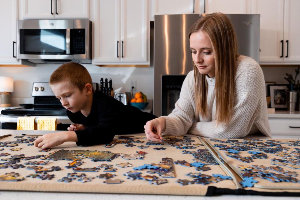 Lauren Hess and one of her children work on a puzzle at their home in Syracuse on Saturday, Jan. 6, 2024. Hess has worked to make her home cozy and to appreciate unique aspects of the season in an effort to boost her mood during the winter. | Megan Nielsen, Deseret News